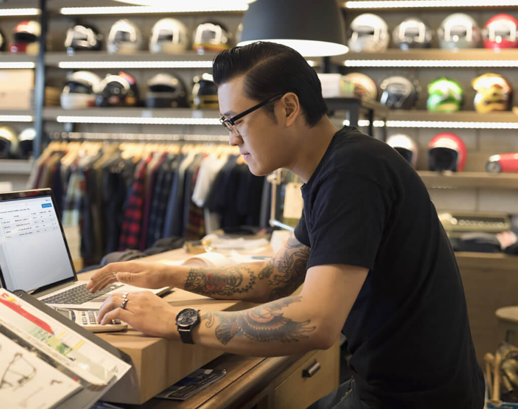 Man in a clothing store working on laptop